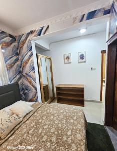 ein Schlafzimmer mit einem großen Bett und einem Gemälde an der Wand in der Unterkunft Elykia in Kinshasa