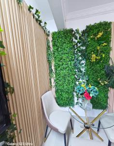 ein Zimmer mit einer grünen Wand mit Stühlen und Blumen in der Unterkunft Elykia in Kinshasa