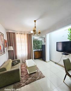 ein Wohnzimmer mit Sofa und Flachbildfernseher in der Unterkunft Elykia in Kinshasa