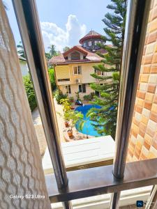 Blick auf den Pool aus dem Fenster in der Unterkunft Elykia in Kinshasa