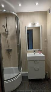 Un baño con ducha, lavabo y bañera. en Apartament Park Podzamcze, en Olsztyn 6 fotos más