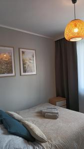 Un dormitorio con una cama y una lámpara de araña. en Apartament Park Podzamcze, en Olsztyn