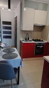 a kitchen with red cabinets and a table and a stove at Apartament Park Podzamcze in Olsztyn
