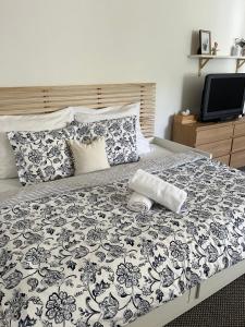 a bed with a black and white blanket and a tv at Chaloupka u kostela in Jeseník nad Odrou
