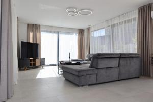 a living room with a couch and a television at Sunset Villa Aves with Pool, Gym and Sauna, Sea view in Rogač