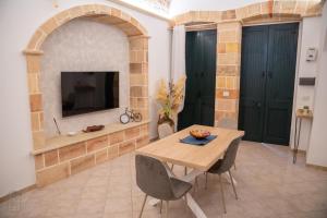 a dining room with a table and chairs and a tv at Mesciu Bruno Casa Vacanza in Copertino