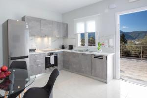 a kitchen with a glass table and a large window at Theros Apartment 1 in Yénion