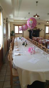 einen langen Tisch in einem Restaurant mit rosa Sonnenschirmen in der Unterkunft La Locanda di San Biagio in Bolzaneto