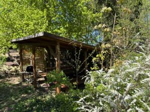 a wooden shelter in the middle of a garden at Apartament Chochlika in Rybczyzna