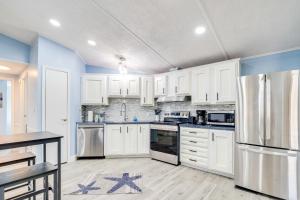 a kitchen with white cabinets and stainless steel appliances at Golf and Pool Access Home with Yard in Lady Lake in Lady Lake