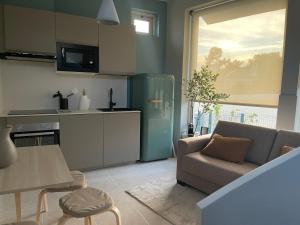 a kitchen and living room with a couch and a table at BestHomeStay- Estoril in Estoril