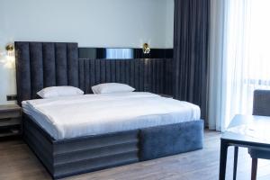 una camera da letto con un letto grande con testiera nera di Fidji Hotel a Yerevan