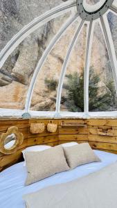 - une chambre avec une grande fenêtre et un lit avec des oreillers dans l'établissement Cocoon Village, à Porto-Vecchio