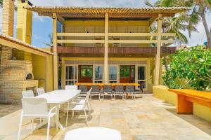 taras z białym stołem i krzesłami w obiekcie Qavi - Villa Jacumã #Luxo w mieście Jacumã