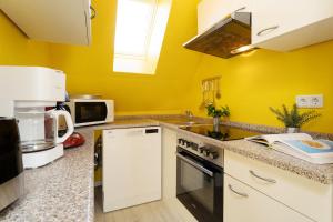 a kitchen with yellow walls and a counter top at Villa FarbenFroh in Fehmarn