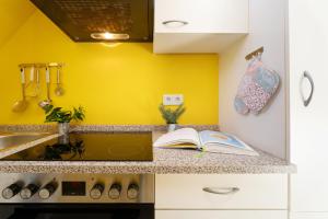 a kitchen with yellow walls and a book on a counter at Villa FarbenFroh in Fehmarn
