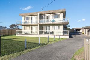 a white house with a fence in front of it at Beachside Nook at Warilla in Lake Illawarra
