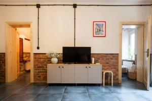 a living room with a tv on a cabinet at Apartamenty KDN Garden in Bielsko-Biała