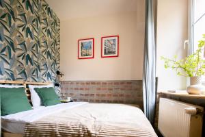 a bedroom with a bed with green pillows at Apartamenty KDN Garden in Bielsko-Biała