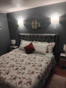 une chambre avec un lit avec un couvre-lit fleuri et deux lampes dans l'établissement Lindo depa en la playa chica, à Papudo