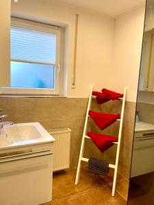 a bathroom with a shelf with red towels on it at Ferienwohnung Schwarzwaldnest im Heimbachtal in Loßburg +14 photos