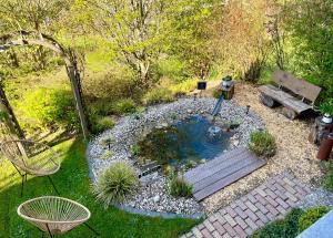 a small pond in a garden with a bench at Ferienwohnung Schwarzwaldnest im Heimbachtal in Loßburg