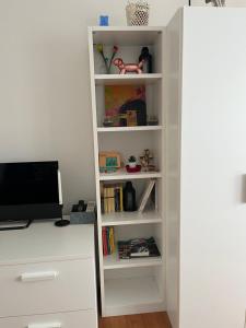 a white book shelf with a computer on a desk at Sweet HOME GEMMA in Mestre