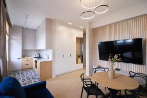 Una sala de estar con una mesa y una cocina. en Heart of Rzeszów Apartment, en Rzeszów