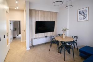 sala de estar con mesa y TV en la pared en Heart of Rzeszów Apartment, en Rzeszów