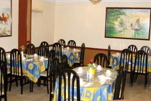 un comedor con mesas y sillas azules y amarillas en Paradise Hotel, en Tanjung Pinang