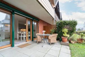 a patio with a table and chairs on the side of a house at Alte Bergstraße 6 Sehnsucht in Scharbeutz