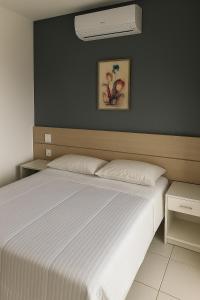 a bedroom with a large bed with a white bedspread at Flat Vista Mar com Piscina e Wi-Fi Rápido Rio Vermelho in Salvador +23 photos
