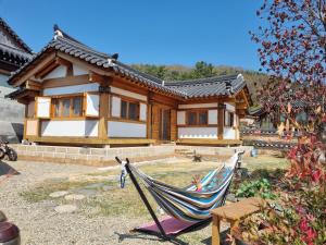 a house with a hammock in front of it at Seondosan Hanok Stay in Gyeongju