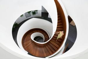 a spiral staircase in a building with a person walking down it at Veranda Resort Phuket, Autograph Collection in Panwa Beach +189 photos