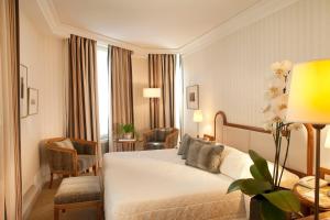 a hotel room with a bed and a chair at Hôtel De l'Arcade in Paris