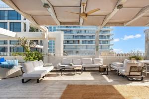 a patio with white furniture and a large building at Trumpeldor 1 - Luxury Beach Apartments Hotel - By Vacay in Tel Aviv