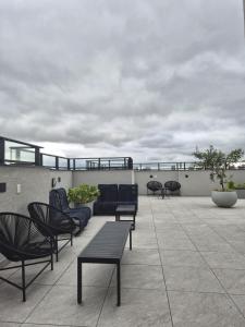 patio z krzesłami i kanapą na dachu w obiekcie Studio Completo e Confortável - Piscina e Academia - Ótima Localização w mieście Kurytyba +35 zdjęć