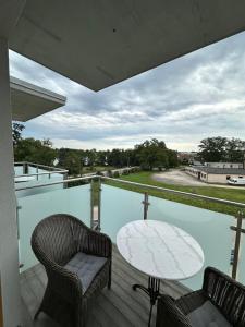 a patio with a table and chairs on a balcony at Apartament 32 Rowery, Spacery w Dolinie Baryczy - 5D Apartamenty in Milicz +22 photos