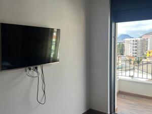 a flat screen tv on a wall with a window at Alex apartment Bar in Bar