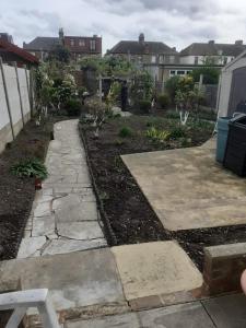 a garden with a stone walkway in a yard at Single Room- Goodmays Train station- London in Seven Kings