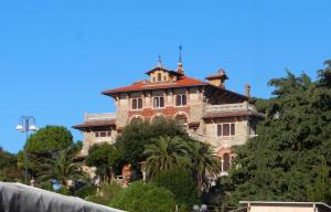 a large building on top of a hill with trees at Garden room with terrace in Genova