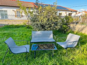 two chairs and a table in the grass at La casita de Soria in Soria
