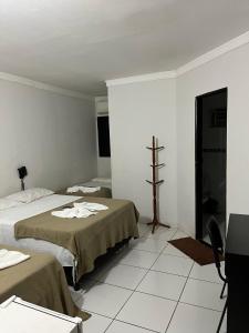 ポコネーにあるHotel e pousada Chalanaのベッド2台が備わる客室で、壁にクロスが付いています。