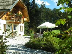 een huis met een balkon en een paraplu bij Ferienwohnung Waldhauser in Hermagor