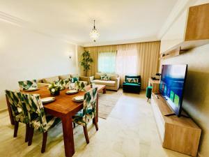 un salon avec une table à manger et une télévision dans l'établissement Apprt luxueux l'Hivernage au centre ville proche de la gare ,M avenu CR07, à Marrakech