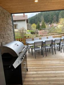 taras zewnętrzny ze stołami, krzesłami i grillem w obiekcie Superbe Chalet refait à neuf, idéal famille, Sportifs 2 nuits minimum w mieście Xonrupt-Longemer