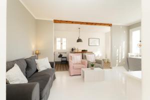 a living room with a couch and a pink chair at Weißes Haus 9123II in Fehmarn
