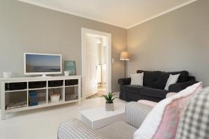 a living room with a couch and a tv at Weißes Haus 9123II in Fehmarn
