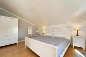 a bedroom with a white bed and a white dresser at Weißes Haus 9123II in Fehmarn