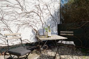 a table with two chairs and a bottle of wine at Weißes Haus 9123II in Fehmarn